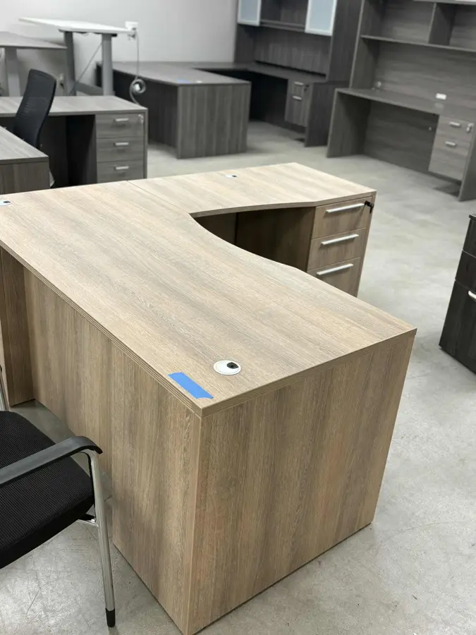 Cherryman Ryker series Aged Oak color curved L shaped desk with step front modesty panel at Peach State Office Furniture, Atlanta
